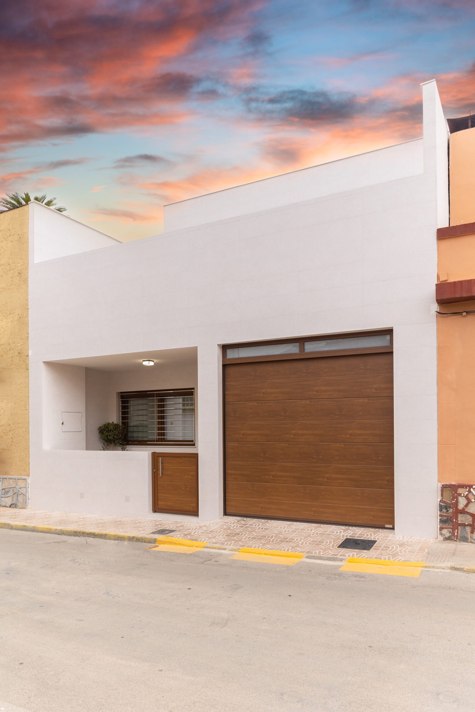 Fachada de villa contemporánea con acabados en piedra y estuco